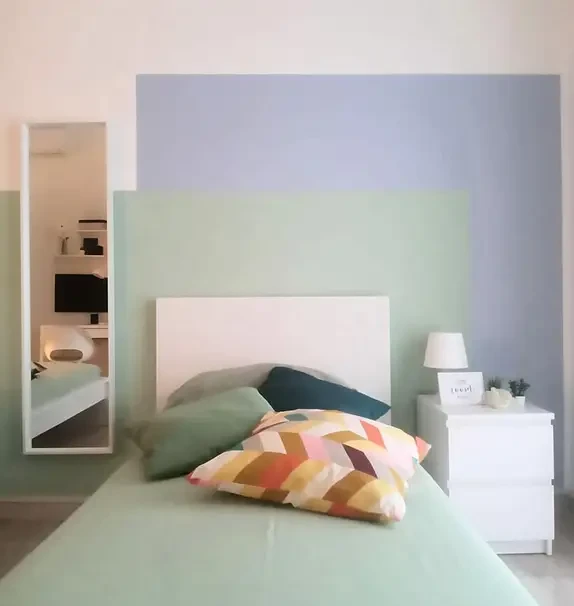 Bed in a bright twin bedroom, in Dergano